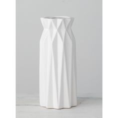 a white vase sitting on top of a table