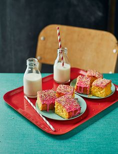 three pieces of cake and milk on a red tray