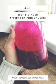 a person holding a jar filled with pink liquid