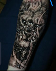 a man's arm with a lion tattoo on it and an arrow in the middle