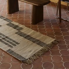 a rug on the floor next to a wooden bench