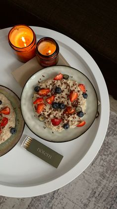 two plates filled with oatmeal and fruit on top of a white table