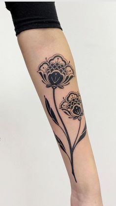 a black and white flower tattoo on the arm