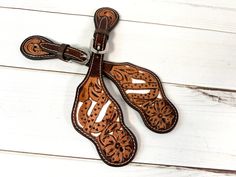 a pair of brown leather stirs sitting on top of a white wooden floor