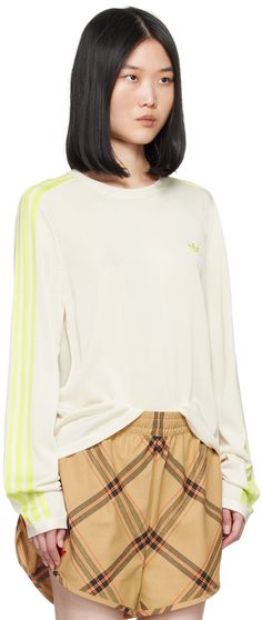 Knit rayon- and recycled polyester-blend T-shirt. · Rib knit crewneck, hem, and cuffs · Logo embroidered at chest and back collar · Intarsia stripes at sleeves Part of the Wales Bonner x adidas Originals collaboration. Supplier color: Chalk white/Semi frozen yellow Sporty Spring Sweater With Embroidered Logo, Sporty Crew Neck Sweater With Embroidered Logo, Sporty Long Sleeve T-shirt With Embroidered Logo, Athleisure Crew Neck T-shirt With Ribbed Cuffs, Sporty Spring Tops With Embroidered Logo, Sporty Crew Neck Tops With Embroidered Logo, Sportswear Top With Three Stripes For Fall, Athleisure Tops With Embroidered Logo, Sportswear Crew Neck Top With Embroidered Logo