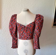 Vintage corset top, floral design in red, black, gray with long puff sleeve, square neck, elastic back and cuffs, fully lined and side zipper. Made of thick cotton fabric, no size listed.  Very good condition These are the exact measurements taken flat: armpit to armpit -  from 40 cm/15.8'' to 44 cm/17.4'' waist -  from 35/ 13.8'' to 38 cm/15'' length - 40 cm/15.8'' It is approximate size - XS - S Please go by the measurements. Fitted Long Sleeve Puff Top With Gathered Sleeves, Fall Fitted Puff Sleeve Top With Gathered Sleeves, Fitted Puff Sleeve Top With Gathered Sleeves For Fall, Fitted Long Sleeve Puff Top With Floral Print, Fall Fitted Puff Sleeve Top With Smocked Bodice, Fitted Puff Sleeve Top With Smocked Bodice For Fall, Red Fitted Top With Square Neck, Fitted Blouse With Smocked Bodice And Square Neck, Fitted Floral Print Puff Sleeve Top With Balloon Sleeves