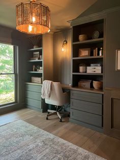 a home office with built - in bookcases and an area rug