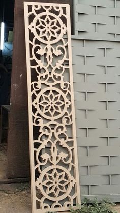 a large wooden cutout on the side of a building next to a planter