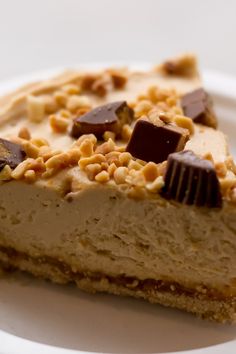 a piece of cheesecake on a plate with chocolate chips and peanut butter toppings