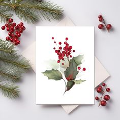 a white card with red berries and green leaves