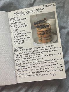 a recipe book with cookies in it sitting on a bed