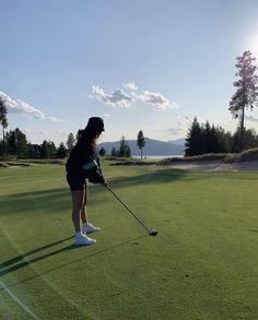 a woman is playing golf on the green