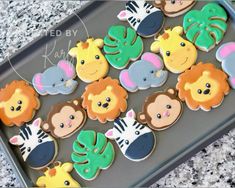 decorated cookies in the shape of animals and giraffes on a cookie sheet