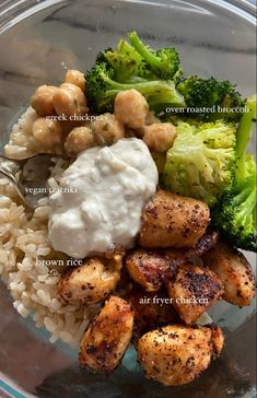 a glass bowl filled with rice, broccoli and chicken on top of it