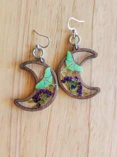 My handcrafted Luna Moth Moon Garden earrings were inspired by a Luna moth visiting it's favorite flower on a clear day. Just a few pieces of nature's beauty captured in a wood framed crystal clear crescent moon for safekeeping. These earrings are made in a multi-step/multi-day process that includes a mix of a wood frame, clear resin, inclusions of preserved dried flowers, a realistic paper specimen, and a clear topcoat. The translucent moons give a clear view of both sides of the earrings. +The Unique Pressed Flowers Earrings, Whimsical Moon-shaped Handmade Earrings, Handmade Whimsical Moon Earrings, Nature-inspired Dangle Flower Earrings, Handmade Nature-inspired Flower Earrings, Resin Inclusions, Garden Earrings, Moon Moth, Resin Uses