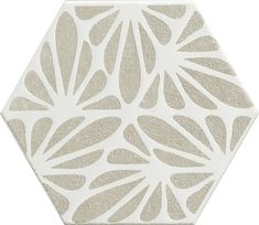 a white and beige hexagonal tile with an intricate design on the front side