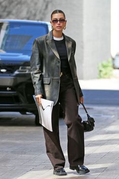 a woman walking down the street with her purse