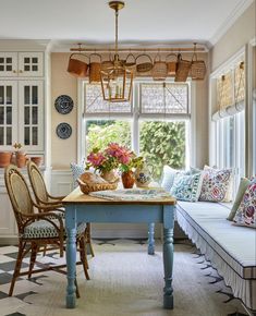 a dining room table with chairs and a bench in front of a window that has flowers on it