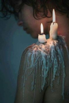 two candles that are on top of someone's body covered in icing and water