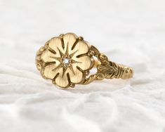 A timeless flower ring modeled after an authentic Victorian antique. DETAILS: Band is 1.75mm wide by 1mm thick Daisy top is 11mm in diameter 1.5mm diamond, ruby or blue sapphire **Choose at checkout Solid 14k yellow, white or rose gold Handmade in Colorado Made to order - Please allow 2-3 weeks for production   Modeled after an authentic Victorian ring, this flower ring design is just as relevant now as it was over one hundred years ago. The ornately-carved details hug close to your finger. The low profile design makes it a breeze to wear everyday. This ring is handmade in solid 14k gold with a flush-set gemstone in the center for a little extra twinkle. This Daisy Ring will be apart of your collection for a lifetime. Wear it as a fashion ring or an alternative engagement ring. Pair it wit Heirloom 14k Gold Flower Ring With Rose Cut Diamonds, Heirloom Rose Cut Diamond Flower Ring As Gift, Heirloom Flower Ring With Rose Cut Diamonds As Gift, Heirloom Flower Ring With Rose Cut Diamonds, Heirloom Flower Ring With Single Cut Diamonds For Anniversary, Heirloom Diamond Flower Ring In Yellow Gold, Classic 14k Gold Flower Ring With Rose Cut Diamonds, Heirloom Yellow Gold Flower Ring Hallmarked, Heirloom 14k Gold Engraved Flower Ring