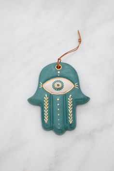 a ceramic hamsa with an evil eye on it