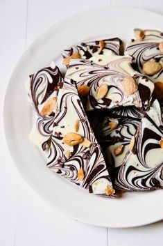 a white plate topped with pieces of chocolate and nuts