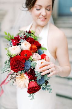 a woman holding a bouquet of flowers in her hands