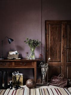 a room with purple walls and striped rug