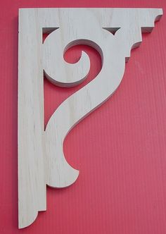 the letter s is made out of wood and sits on a pink surface with white paint