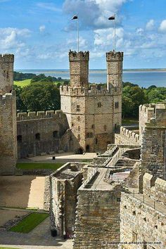 an aerial view of a castle with two towers and flags flying in the sky above