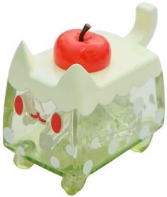 an apple is sitting on top of a small plastic box with polka dots and green leaves