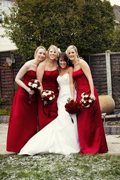 three bridesmaids in red dresses posing for the camera