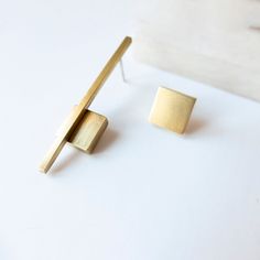 These pair of minimalis gold earrings is the combination of two mismatched earrings: A brass square and a bar earring and an square earring. When you place the order you will choose which of the two earrings you prefer for the right  and the left side. The geometric shapes and the design are inspired by architecture and Bauhaus Style. They are an asymmetrical earrings designed and made of brass in my workshop in Madrid (Spain). The contemporary jewelry is perfect for your urban outfits and great Matte Gold Minimalist Earrings For Everyday, Minimalist Geometric Earrings, Architectural Earrings, Brooch Design, Bar Earring, Architectural Jewelry, Abstract Jewelry, Contemporary Accessories, Asymmetrical Earrings