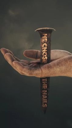 a person's hand holding an old hammer with the word rescue on it, against a dark background