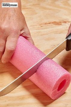 a person holding a pink sponge and a knife