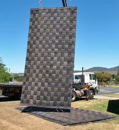 a truck is parked in front of a large sculpture that looks like it has been made out of bricks