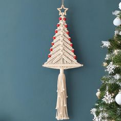 a white christmas tree hanging from the side of a wall next to a decorated christmas tree