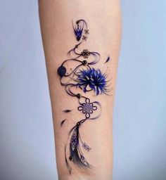 a woman's leg with blue flowers and feathers on it