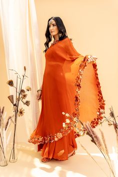 Editor's Note Floral Embroidered Drape With High Waist Pallazo And Blouse Color: Orange Fabric: Georgette,shantoon Embroidery Details: Machine Embroidered Floral Embroidery With Mix Media Hand Embroidery And Swaroski Crystal Embellishments Care: Dry Clean Only About the Designer Founded by Silky Bindra, the couture brand under the label “Silky Bindra” is a very popular bridal wear option with chic, feminine, and elegant pieces, for any and every occasion. Embroidered Cape, Neeta Lulla, Palazzo Set, Orange Blouse, Embroidered Neckline, Cape Dress, Orange Fabric, Fashion App, Mix Media