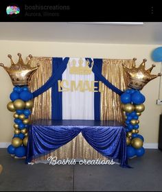 a stage set up with blue and gold balloons for a royal themed birthday or baby shower