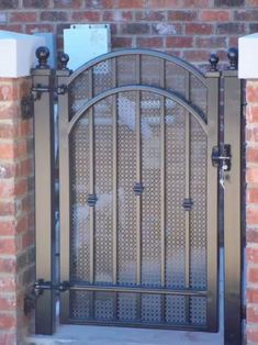 an iron gate is shown in front of a brick wall