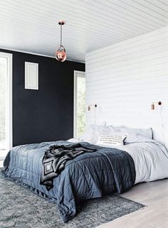 a bedroom with black walls and white bedding is pictured in this image from the front