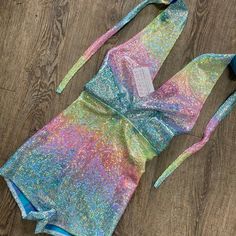 Made of our rainbow avatar holographic spandex, this halter romper hugs the body, but offers plenty of stretch. The halter top ties at the back of the neck. Our seamless front design is extremely comfortable and prevents camel toe. Wear this to a rave, to a festival, or an aerial performance. Summer Party T-back Halter Top, Stretch Disco Bodysuit For Summer, Multicolor Stretch Halter Neck Bodysuit, Multicolor Backless Swimwear For Party, Multicolor Backless Bodysuit For Party, Summer Festival Stretch Jumpsuits And Rompers, Multicolor Triangle Halter Top For Party, Spring Party Bodysuit With Triangle Top, Disco Bodysuit For A Summer Night Out