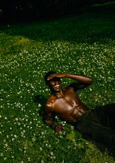 a man laying in the grass with his hands on his head