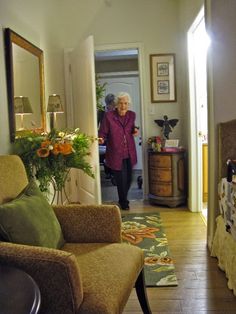 an older woman is walking into the living room