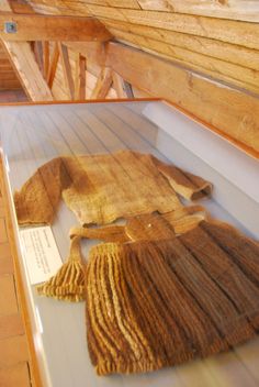 an old piece of cloth is on display in a museum case with wooden slats