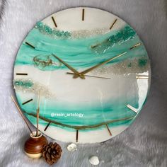 a clock that is on top of a white surface with blue and green paint in the middle