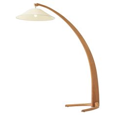 a wooden floor lamp with a white shade on it's head and arm, in front of a white background