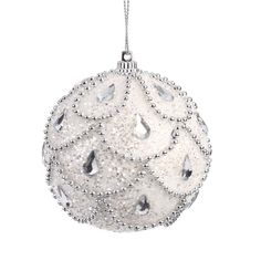 a white ornament hanging from a silver chain on a white background with water drops