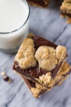 chocolate chip cookie bars stacked on top of each other next to a glass of milk